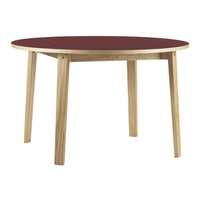 Round table with a rich burgundy top and natural wood legs, featuring a simple, modern design.