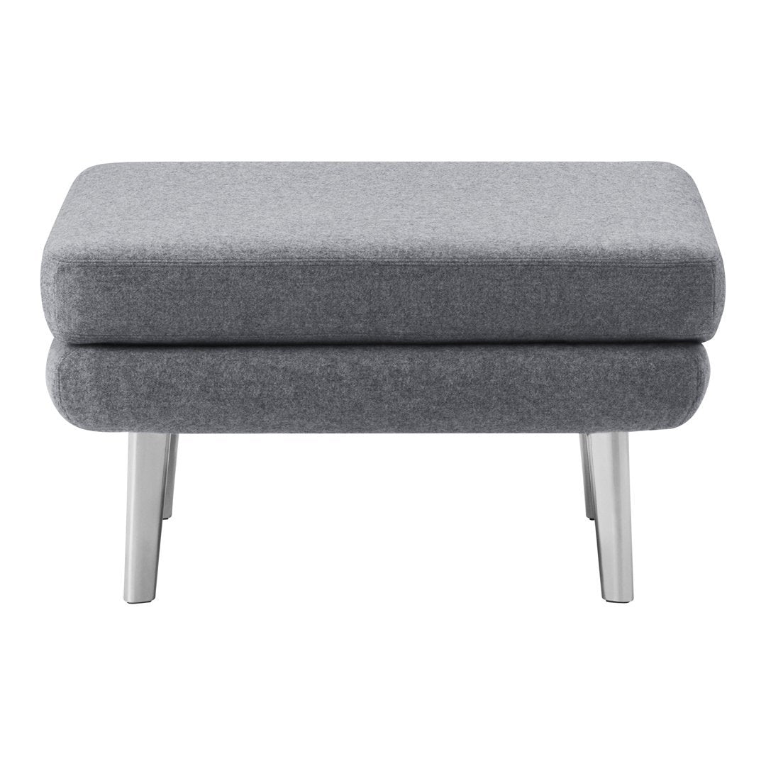 Gray upholstered ottoman with a sleek, minimalist design and silver legs, perfect for modern decor.