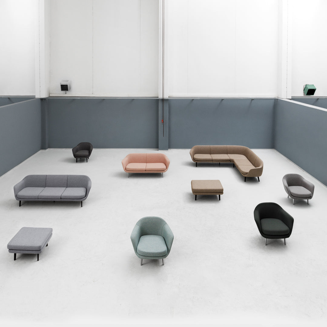 Modern sofas in various colors: muted gray, soft pink, earthy tones, and teal, featuring minimalist designs and clean lines.