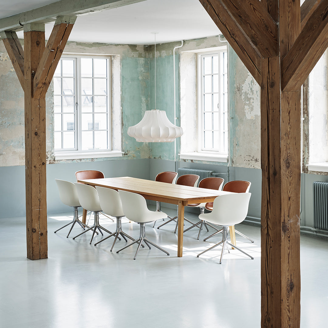 Light blue and white walls with natural wood accents; modern chairs in white and brown around a simple wooden table.