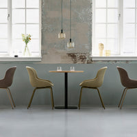 Elegant seating in soft beige and brown, complemented by a minimalistic table and textured gray wall. Modern decor.