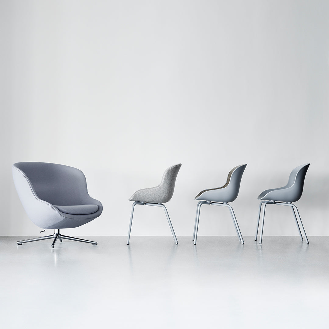 Gray armchair and four sleek gray chairs on a minimalist white background, showcasing modern design and subtle patterns.