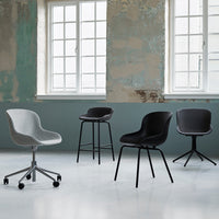 Four stylish chairs in grey and black hues, featuring smooth and textured patterns against a vintage backdrop.