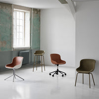 Four modern chairs in earthy tones: rust, olive green, and neutral shades, set against a minimalistic backdrop.