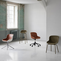 Contemporary chairs in brown, cream, and olive green against a minimalist backdrop with subtle textures.