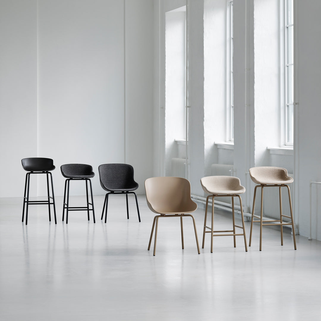 Six stylish chairs in black, dark gray, and light beige, featuring minimalist design and smooth, curved patterns.