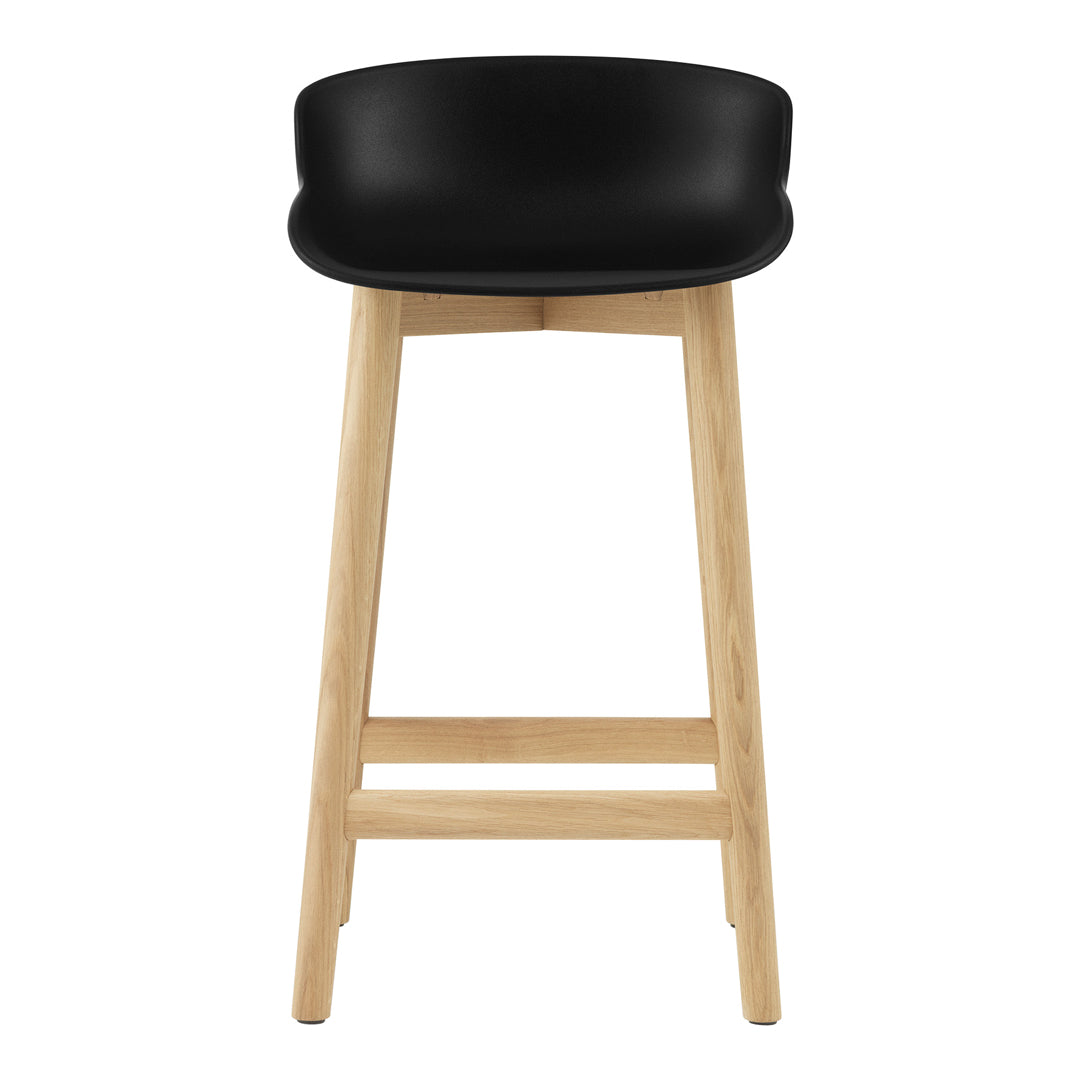 Black seat with smooth, curved edges paired with natural wood legs in a light finish. Modern, minimalist design.