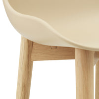 Beige curved seat with natural wooden legs. Sleek, minimalist design, perfect for modern decor.