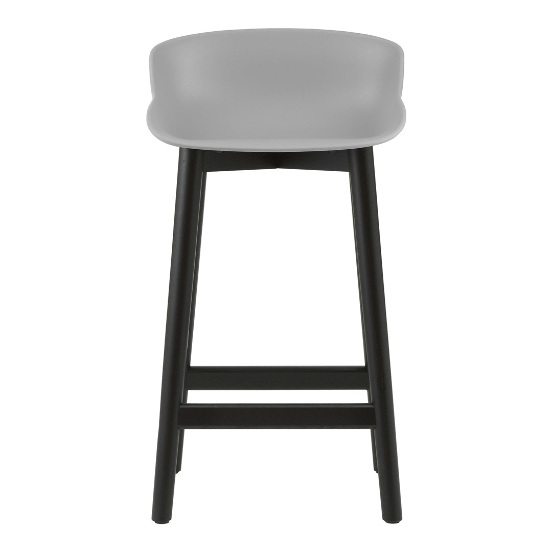 Gray upholstered bar stool with a smooth finish and black wooden legs. Minimalist design for modern decor.