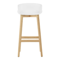 White cushioned stool with natural wood legs, minimalist design and smooth, clean lines. Perfect for modern spaces.