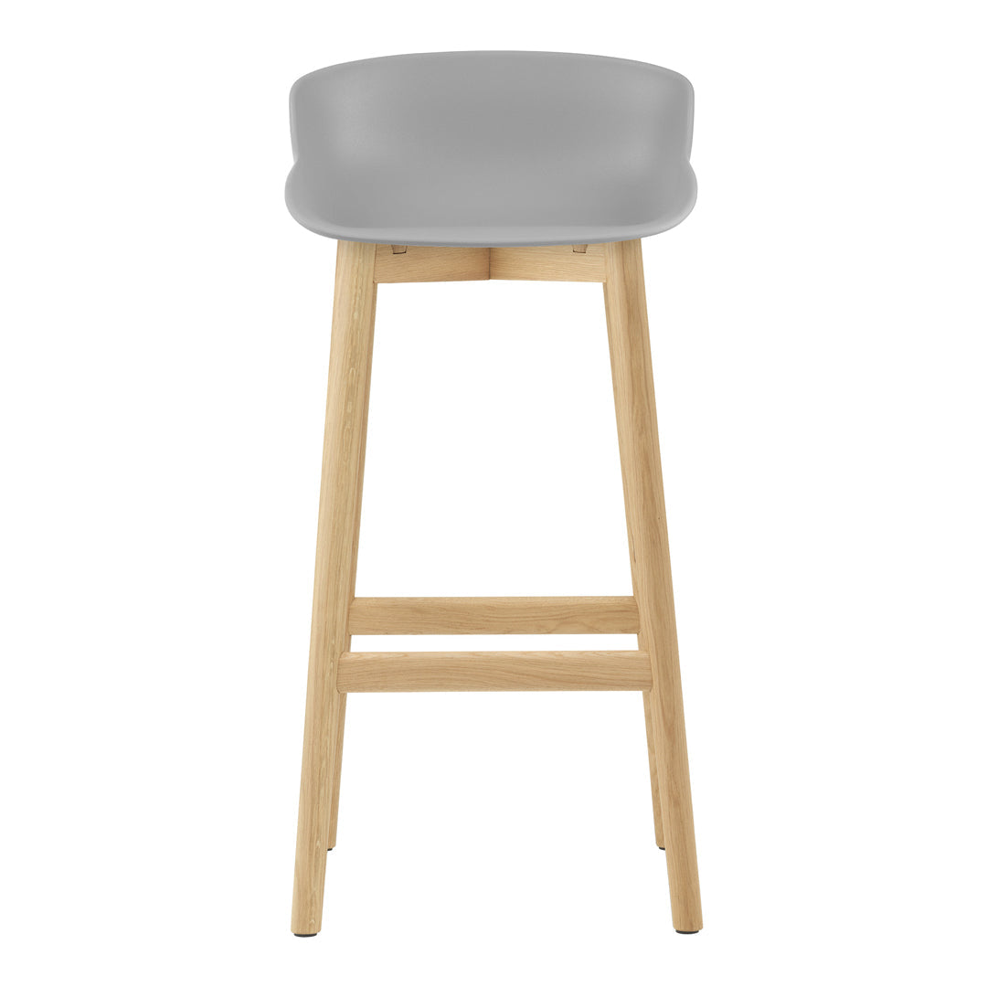 Gray bar stool with a smooth, contoured seat and natural wood legs, offering a sleek and modern design.