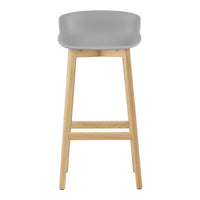 Gray bar stool with a smooth, contoured seat and natural wood legs, offering a sleek and modern design.