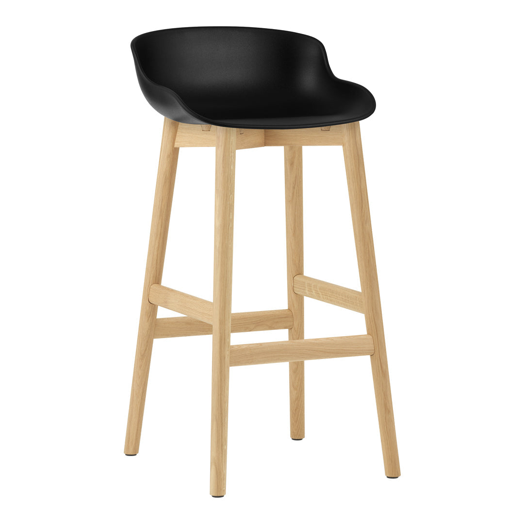 Black molded seat with natural wood legs, minimalist design for modern decor.