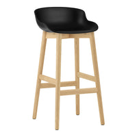 Black molded seat with natural wood legs, minimalist design for modern decor.