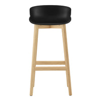Black cushioned seat bar stool with natural wood legs, featuring a modern and minimalist design.