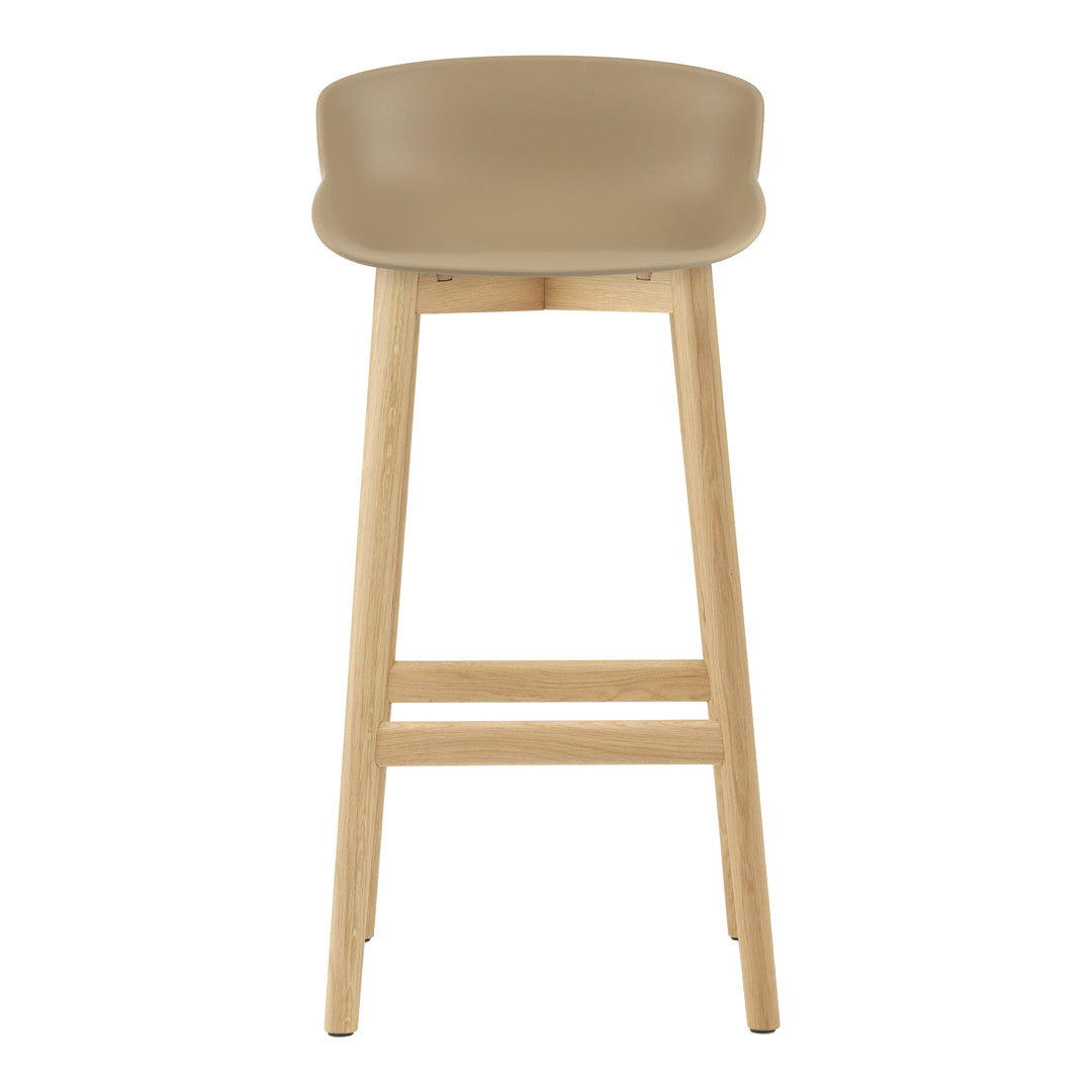 Beige bar stool with a smooth curved seat and natural wood legs. Minimalist design and neutral color palette.