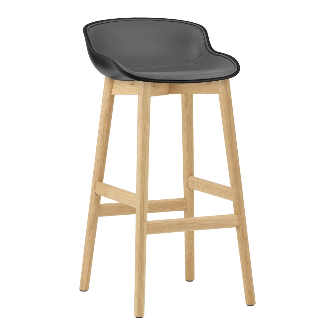 Black upholstered bar stool with a sleek design and natural wood legs. Modern and minimalist aesthetic.