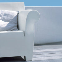 White contemporary sofa arm with smooth curves, complemented by a light gray cushion against a blue sky background.