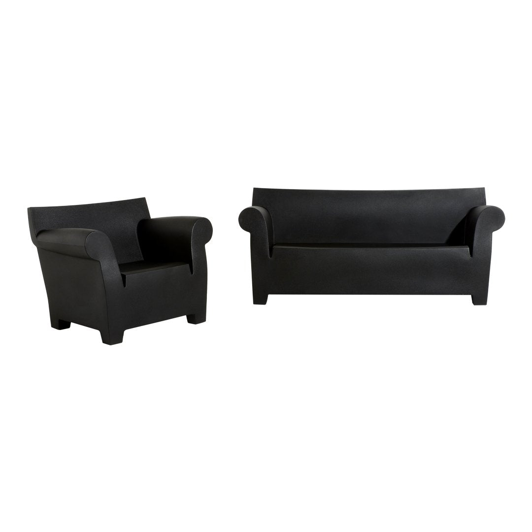 Black sofa and armchair set with smooth, minimalist design and solid color, ideal for modern home decor.