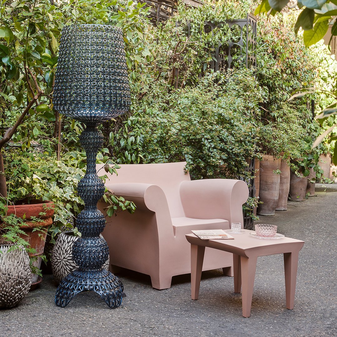 Blush pink armchair with smooth, minimalist design and rounded armrests, perfect for modern interiors.
