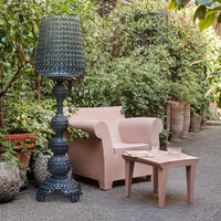 Blush pink armchair with smooth, minimalist design and rounded armrests, perfect for modern interiors.