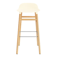 Cream-colored seat with natural wood legs and a sleek silver footrest, perfect for modern interiors.