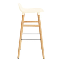 Cream-colored seat with natural wood legs and silver accents, showcasing a minimalist design. Perfect for modern spaces.