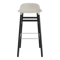 Stylish bar stool in light gray seat with sleek black wooden legs and a minimalist design. Perfect for modern decor.