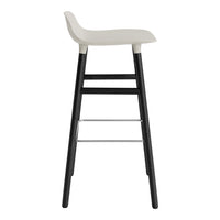 White seat with black legs and silver footrest, simple and modern design for stylish seating.