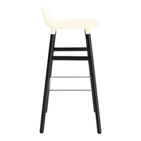 Cream seat bar stool with sleek black legs and silver footrest detail. Modern design for stylish interiors.