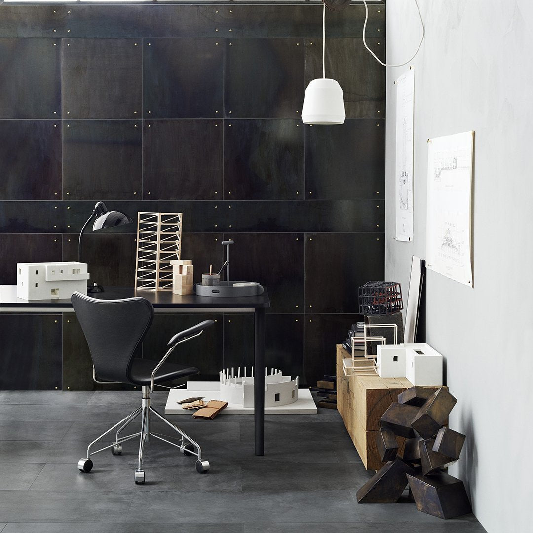 Modern workspace featuring black metal accents, gray walls, and natural wood textures with sleek white lighting.