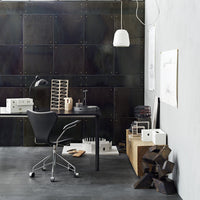 Modern workspace featuring black metal accents, gray walls, and natural wood textures with sleek white lighting.