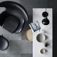 Modern gray and black decor with smooth textures and minimalist patterns, featuring a sleek table and stylish chair.