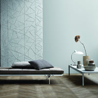 Gray geometric wall pattern, soft gray cushions, and polished wood flooring create a modern, minimalist aesthetic.