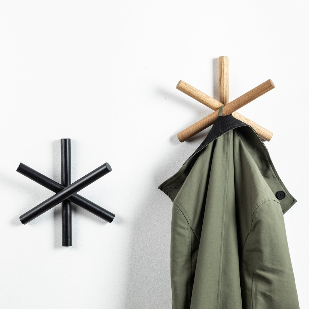 Wooden and black wall hooks in star shapes, showcasing natural wood and sleek black finishes against a white background.