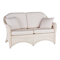 Cream-colored wicker loveseat with soft, textured fabric cushions in a neutral tone. Subtle elegance for any space.