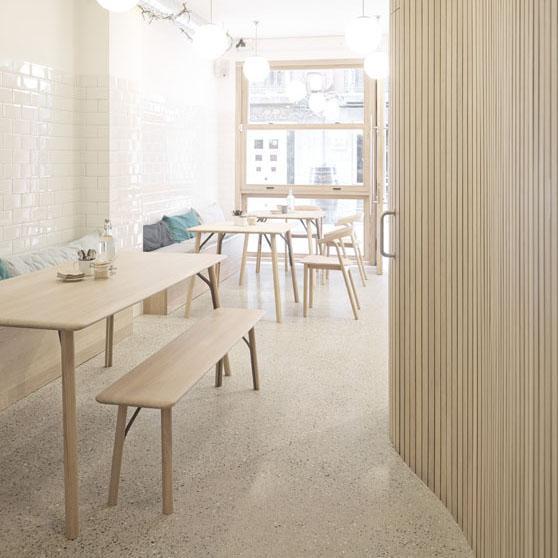 Light wood furniture in a minimalist room with soft pastel accents and textured tile patterns.
