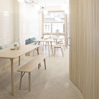 Light wood furniture in a minimalist room with soft pastel accents and textured tile patterns.