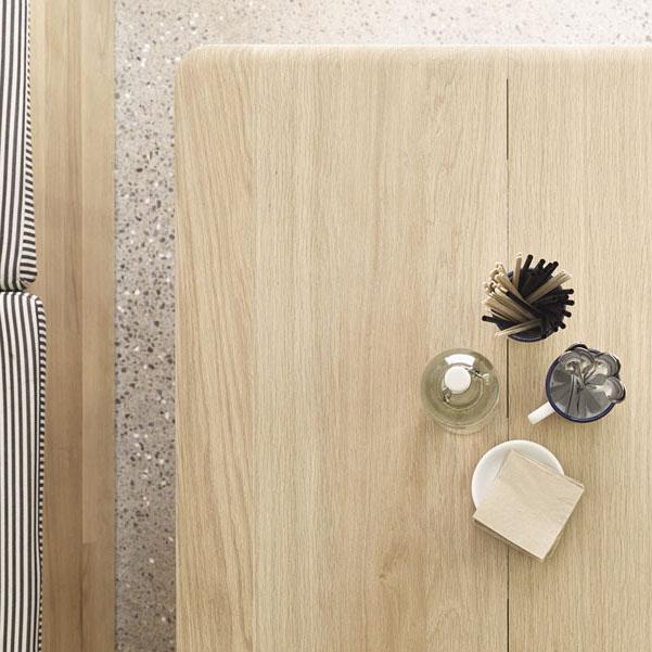 Light oak table with a smooth finish, featuring black and white striped patterns in the background.