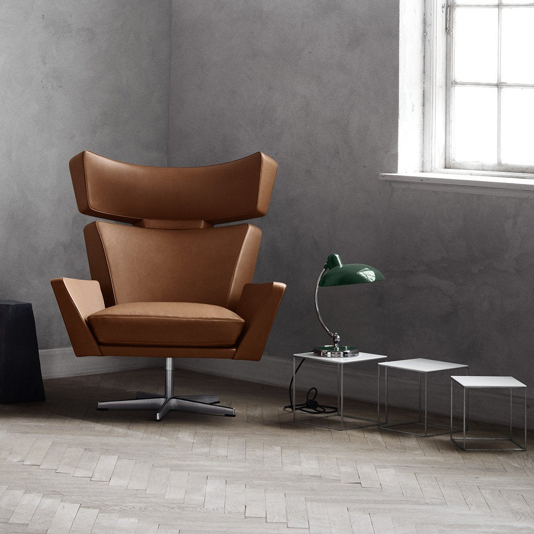 Modern brown accent chair with a sleek design, featuring smooth upholstery and a polished chrome base.