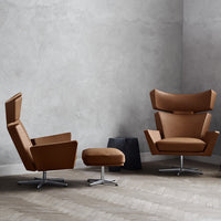 Brown upholstered chairs with sleek, modern designs and circular bases, set against a neutral gray wall.