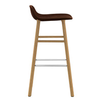 Stylish bar stool featuring a rich brown seat and natural wood legs with a sleek silver footrest.