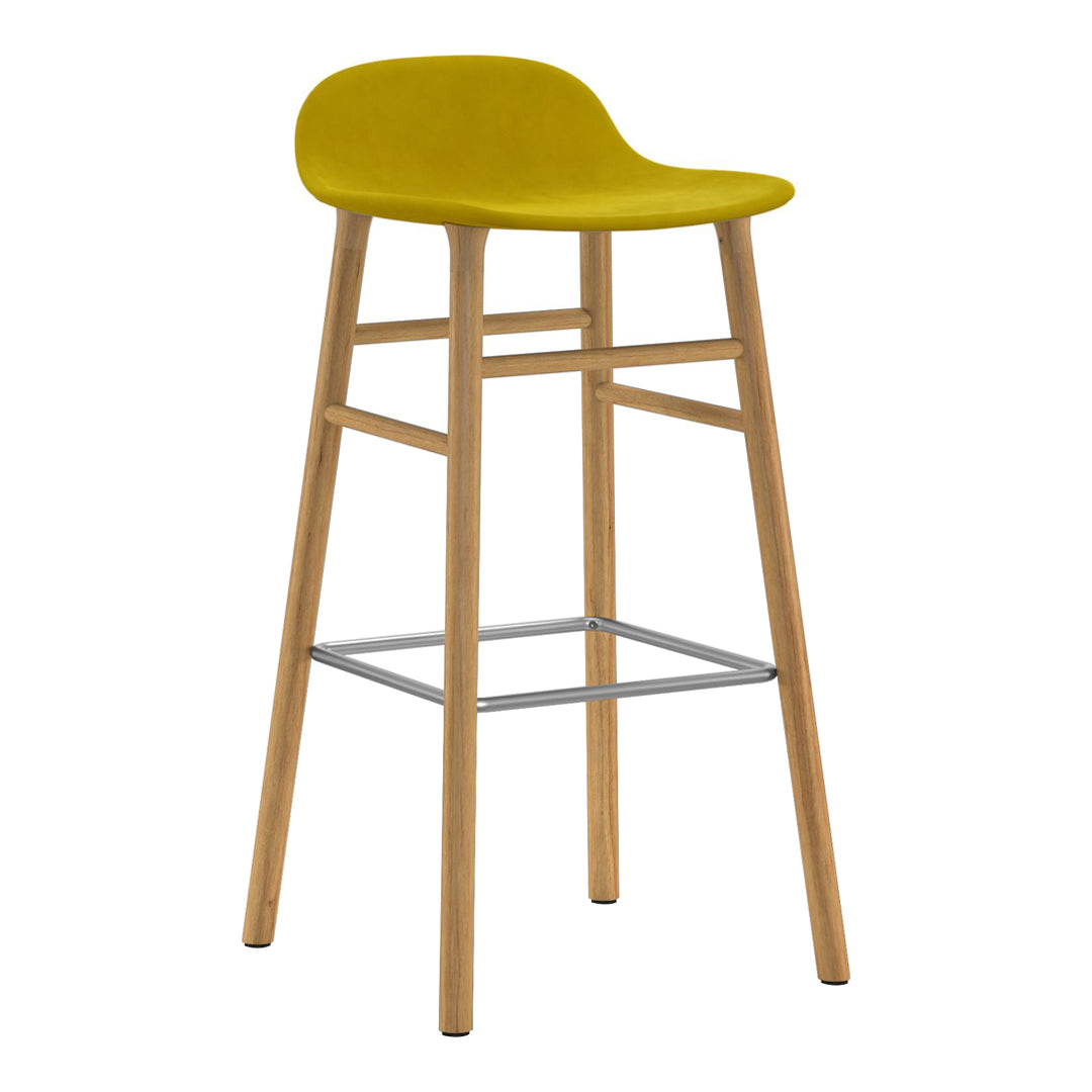 Yellow padded bar stool with natural wood legs and a sleek silver footrest. Modern and vibrant design perfect for any space.