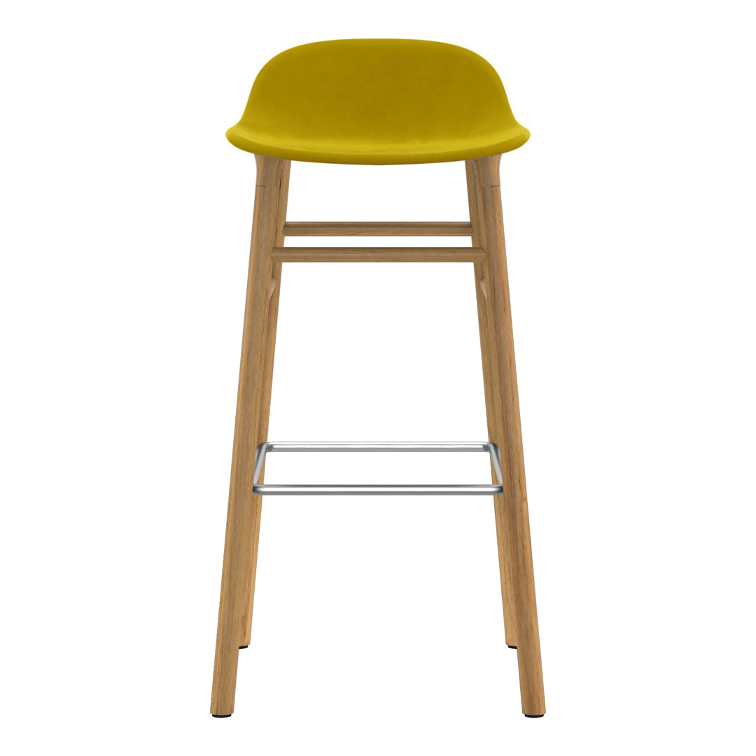 Yellow upholstered bar stool with natural wood legs and a metallic footrest, showcasing a modern, minimalist design.