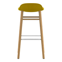 Yellow upholstered stool with wooden legs and silver footrest, featuring a sleek, modern design.