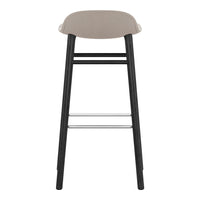 Stylish bar stool featuring a smooth beige seat and sleek black wooden legs with a silver footrest.