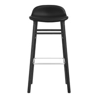 Black bar stool with a smooth, curved seat and a minimalist wooden frame featuring a sleek chrome footrest.