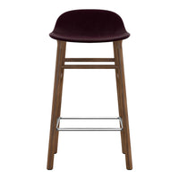 Burgundy velvet barstool with natural wood frame and silver footrest, featuring a sleek, modern design.