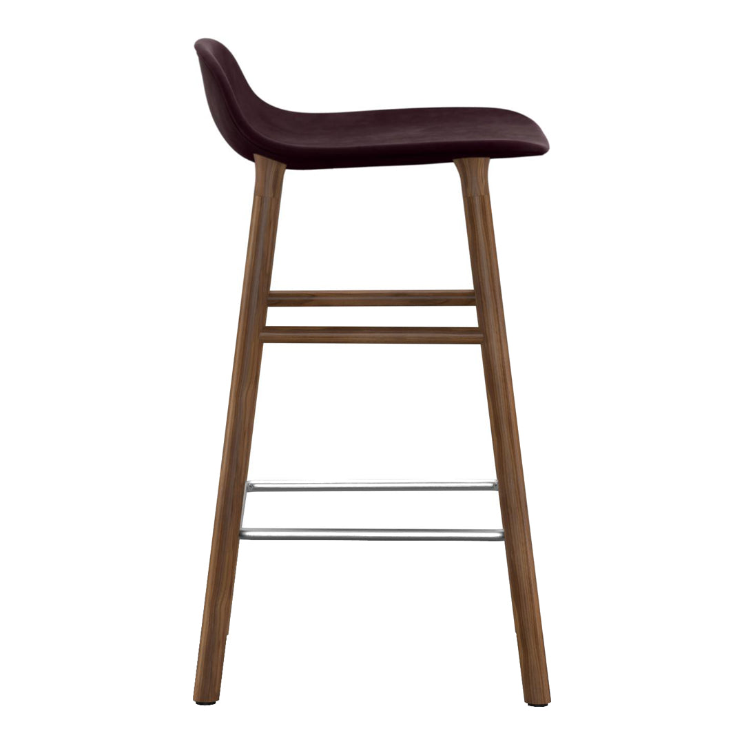Burgundy padded bar stool with natural wood legs and a sleek minimalist design. Perfect for modern interiors.