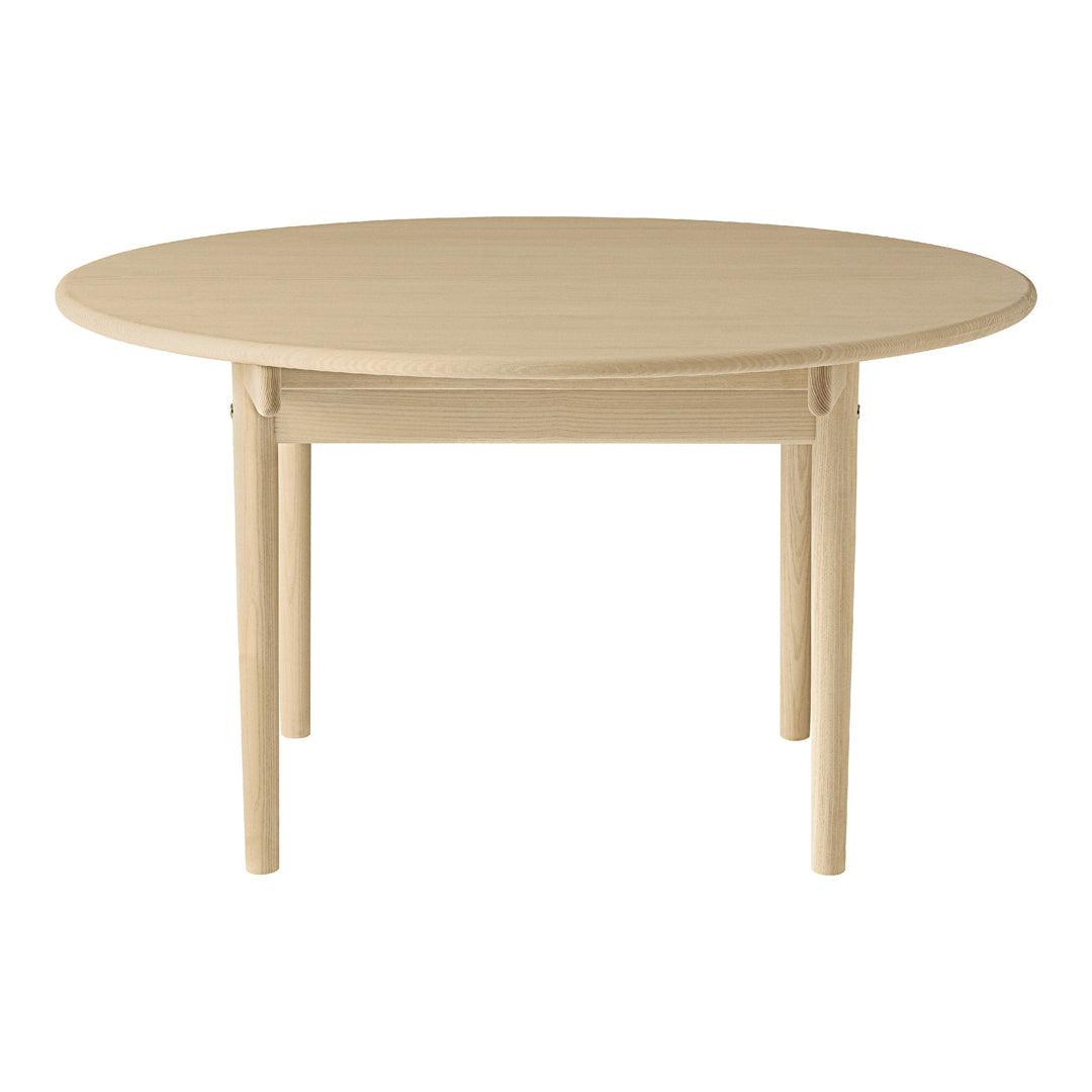 Round wooden table in a light beige finish with a smooth, minimalist design. Perfect for modern dining spaces.